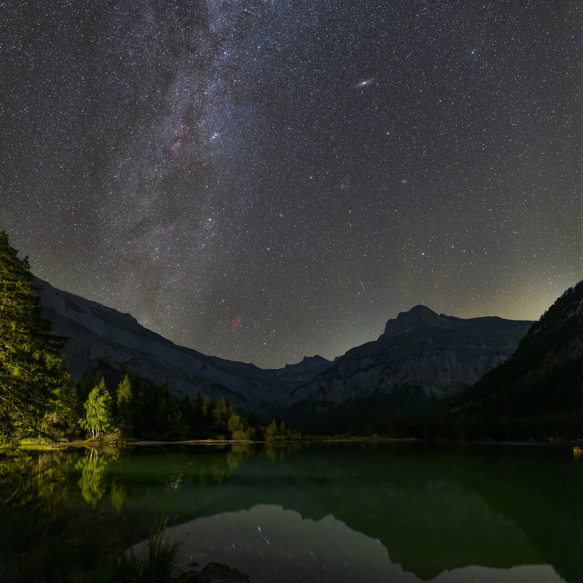 Voie lactée dans un ciel étoilé au-dessus des montagnes de Derborence et de leur reflet dans le lac.
