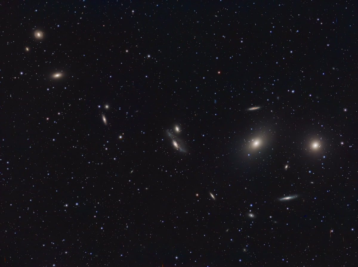 Suite de petites galaxies ovales et allongées formant une courbe sur un fond noir ponctué d’étoiles.