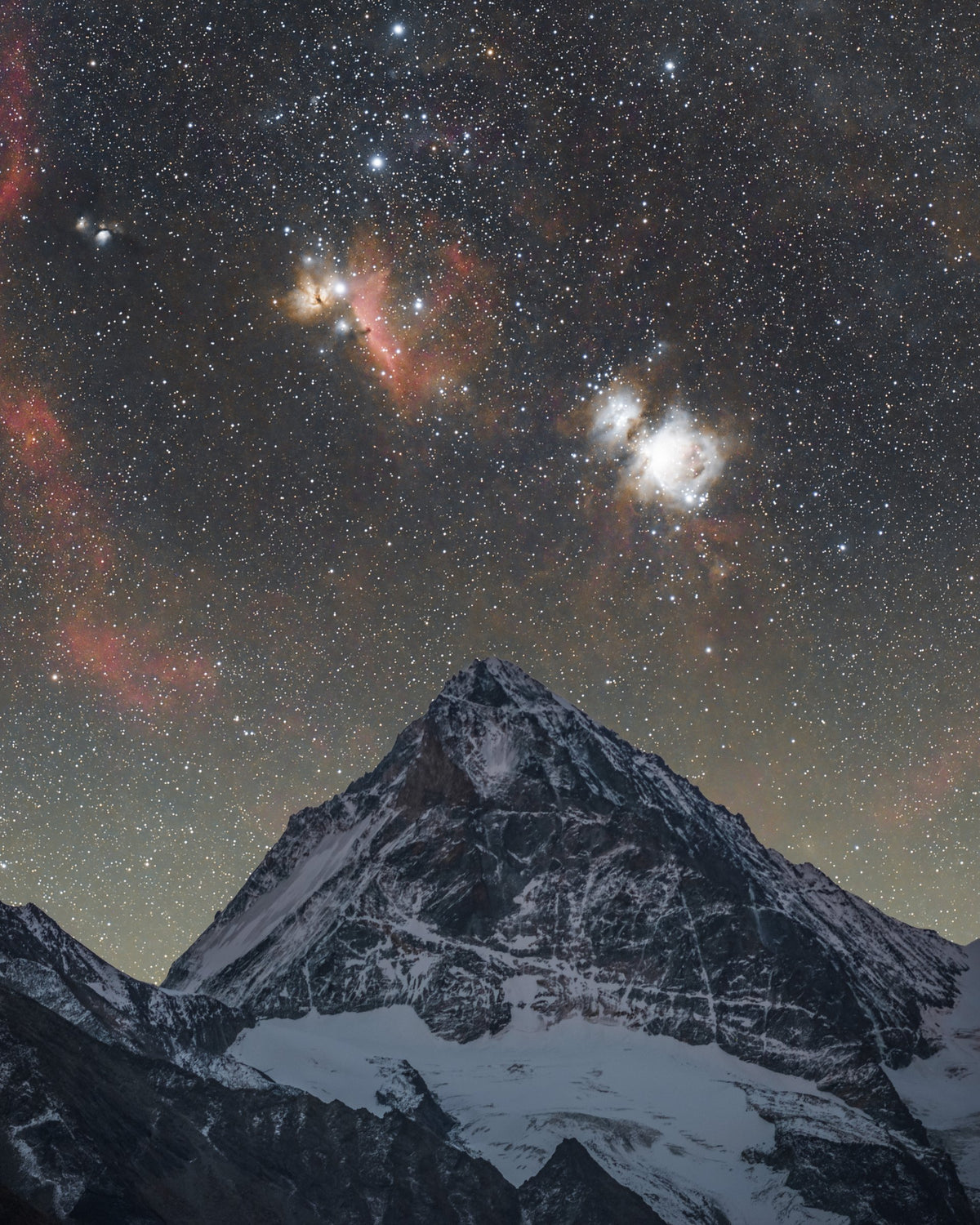 Sommet enneigé de la Dent Blanche sous un ciel étoilé où se distingue la région lumineuse d’Orion.