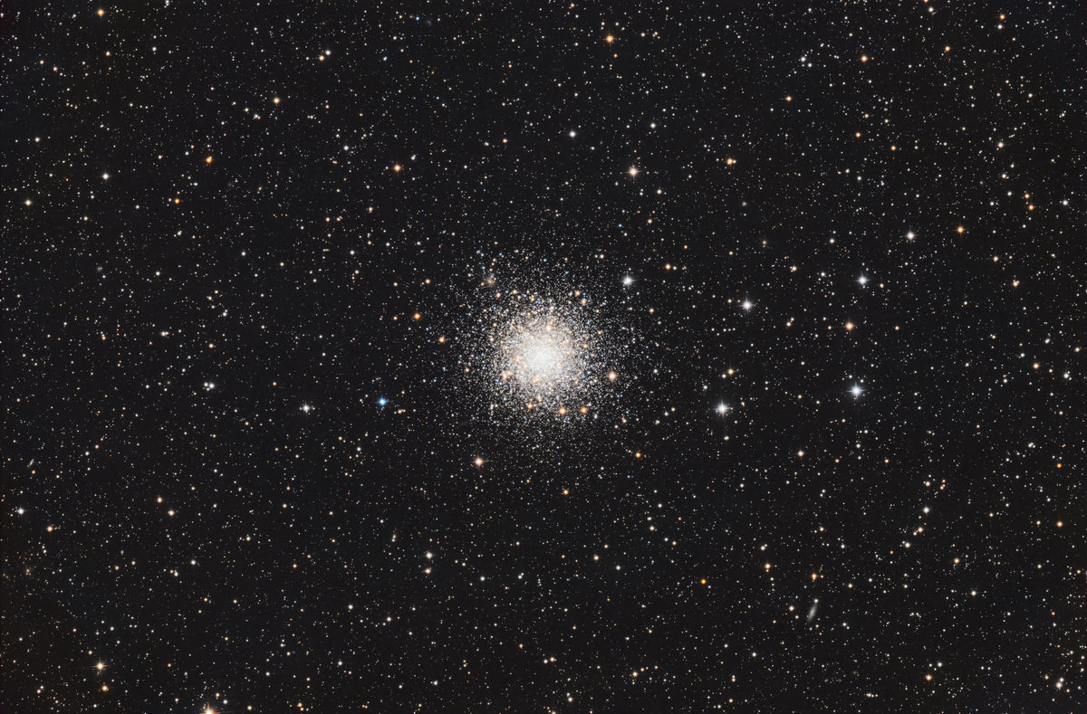 Amas arrondi d’étoiles de Messier 12, avec un centre clair et des étoiles dispersées sur fond noir.