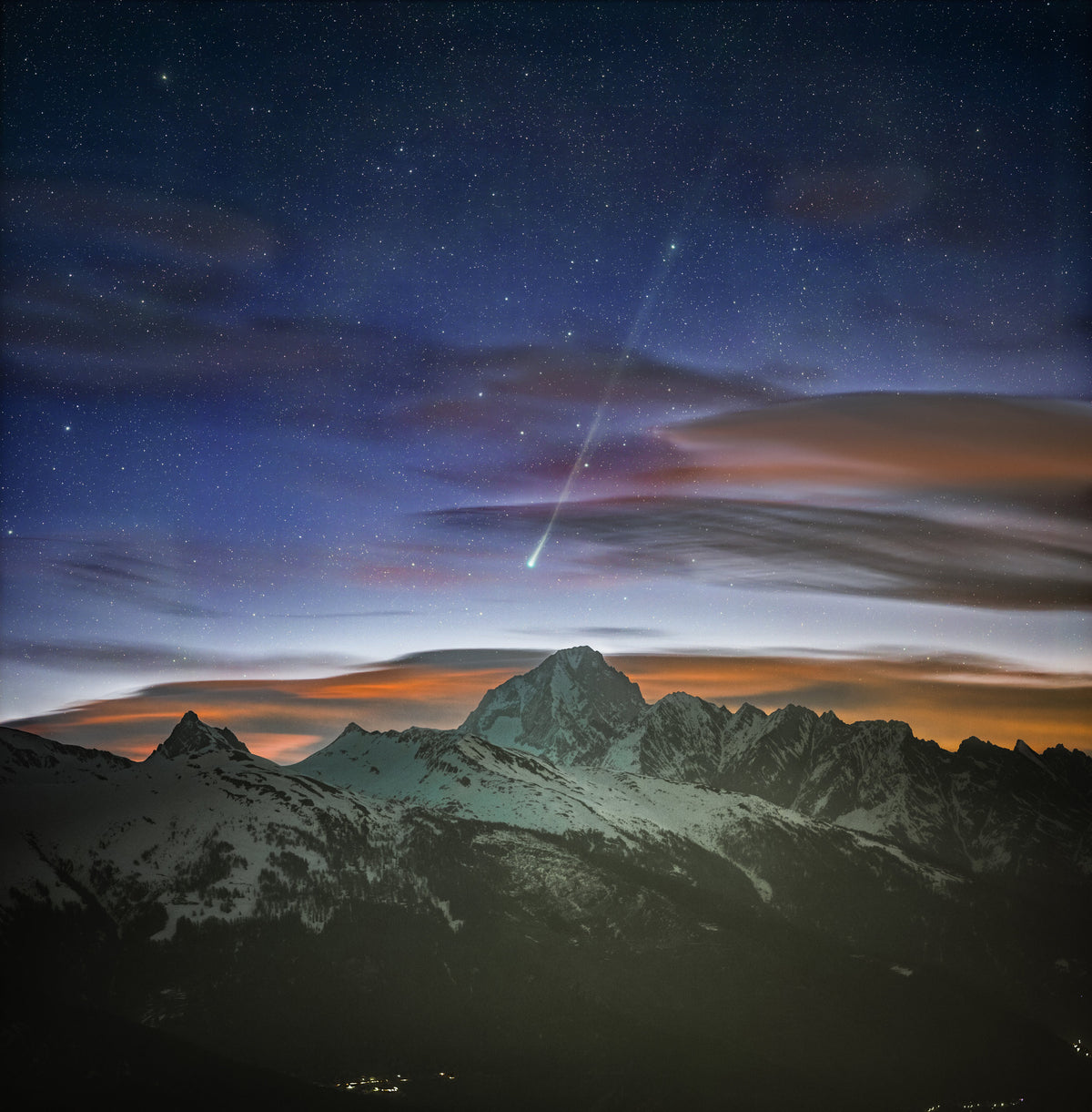 Ciel étoilé et nuages au-dessus des sommets, avec la comète PANSTARRS dans le ciel du Bietschhorn.