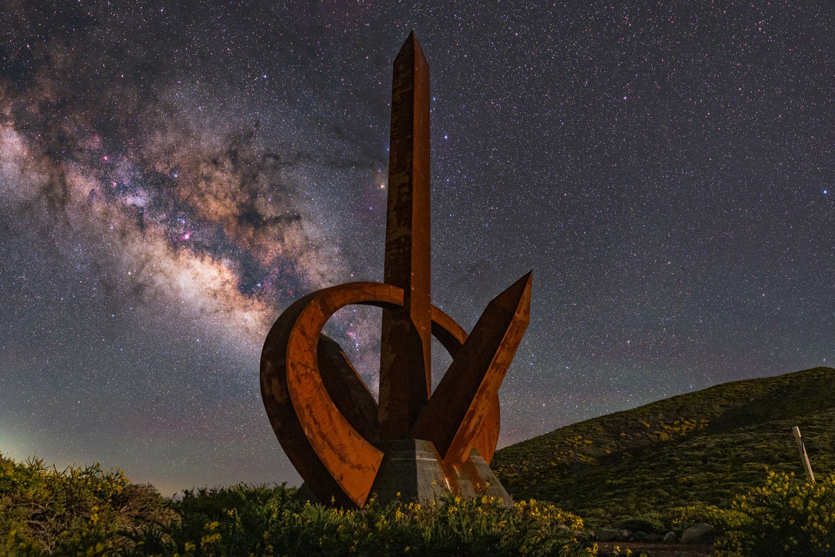 Sculpture du Monumento del Infinito dressée au premier plan, devant la Voie lactée dans le ciel de La Palma.