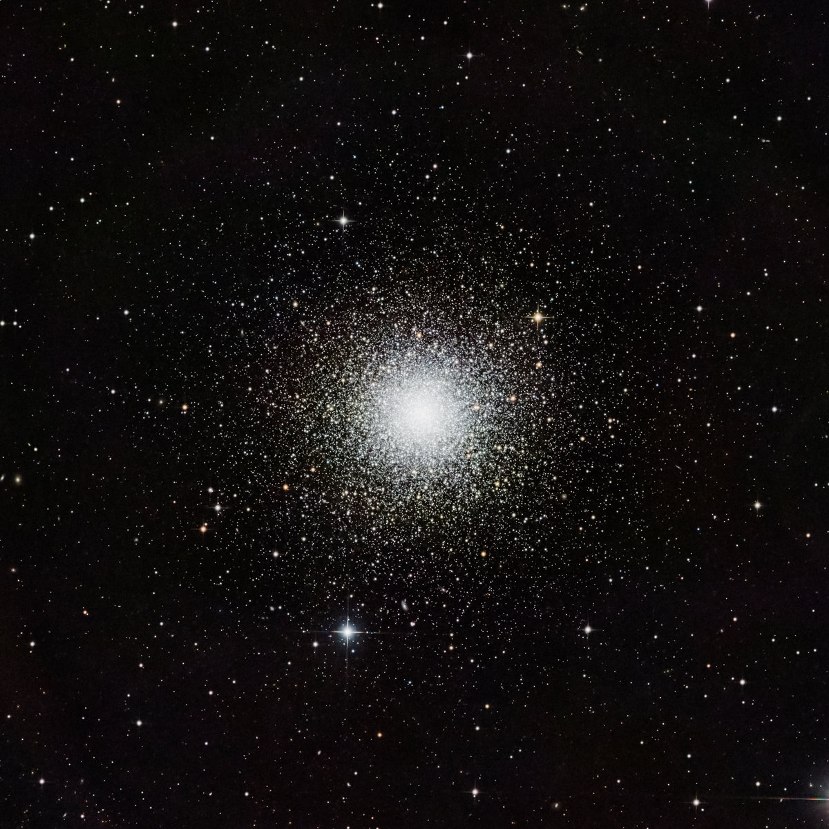 Amas globulaire Messier 3, petite sphère d’étoiles au cœur blanc dense sur un fond noir étoilé.