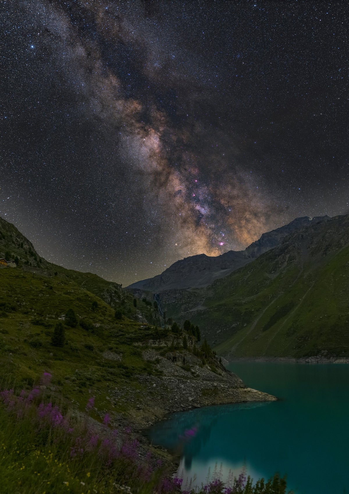 Voie lactée verticale au-dessus du lac de Cleuson, avec une eau turquoise et des versants rocheux sombres.